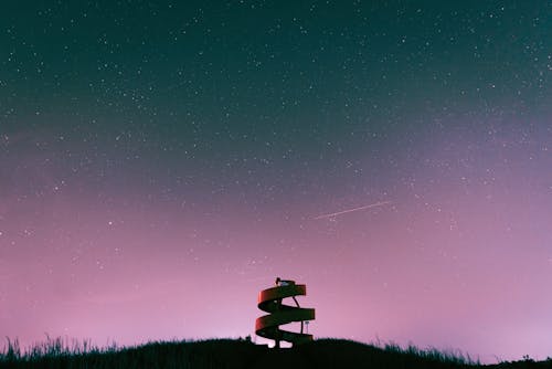 A sign on a hill with a starry sky in the background