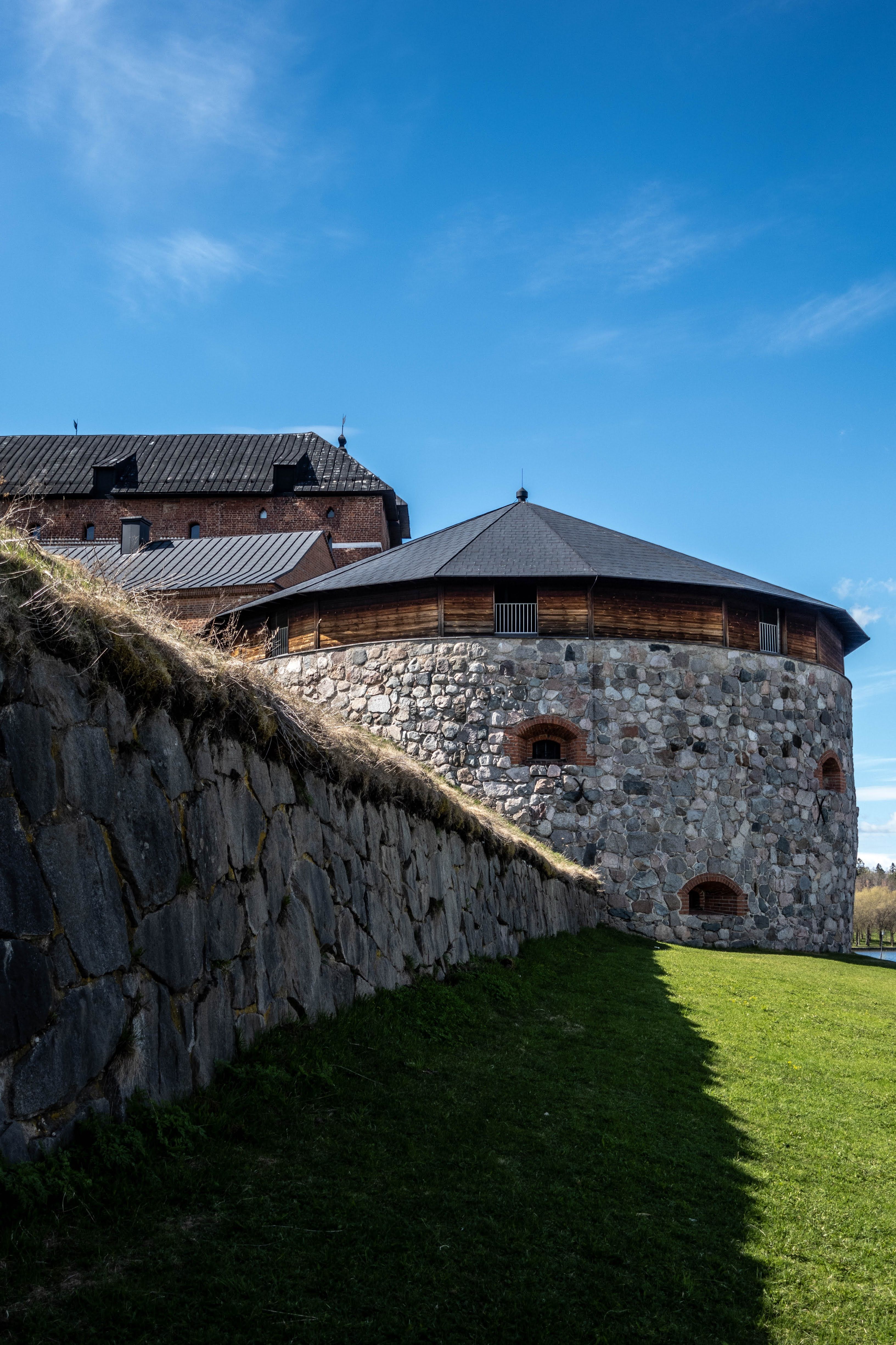 Historic stone tower of Häme Castle in Hämeenlinna, Finland under a clear blue sky.