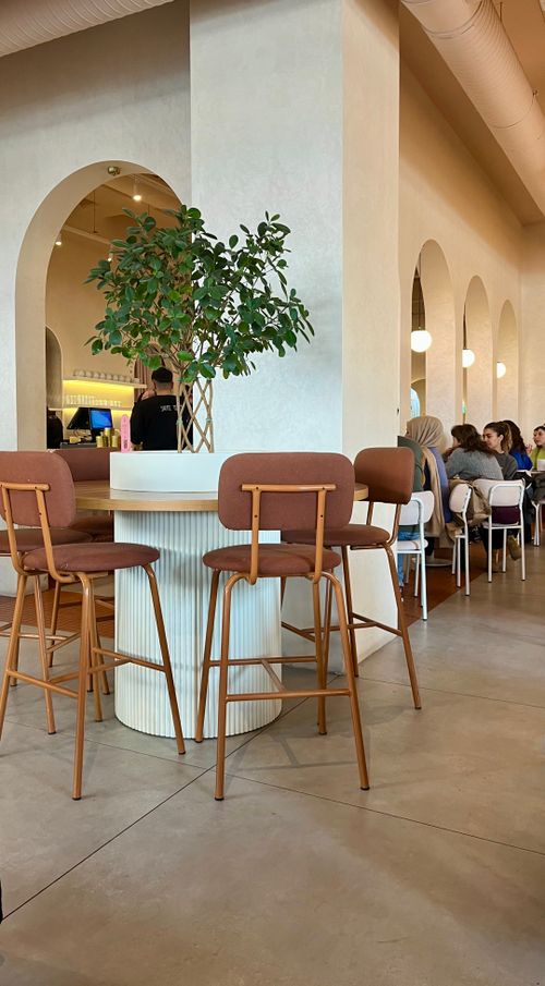 Free Chic café interior featuring elegant arches and cozy seating with ambient lighting. Stock Photo