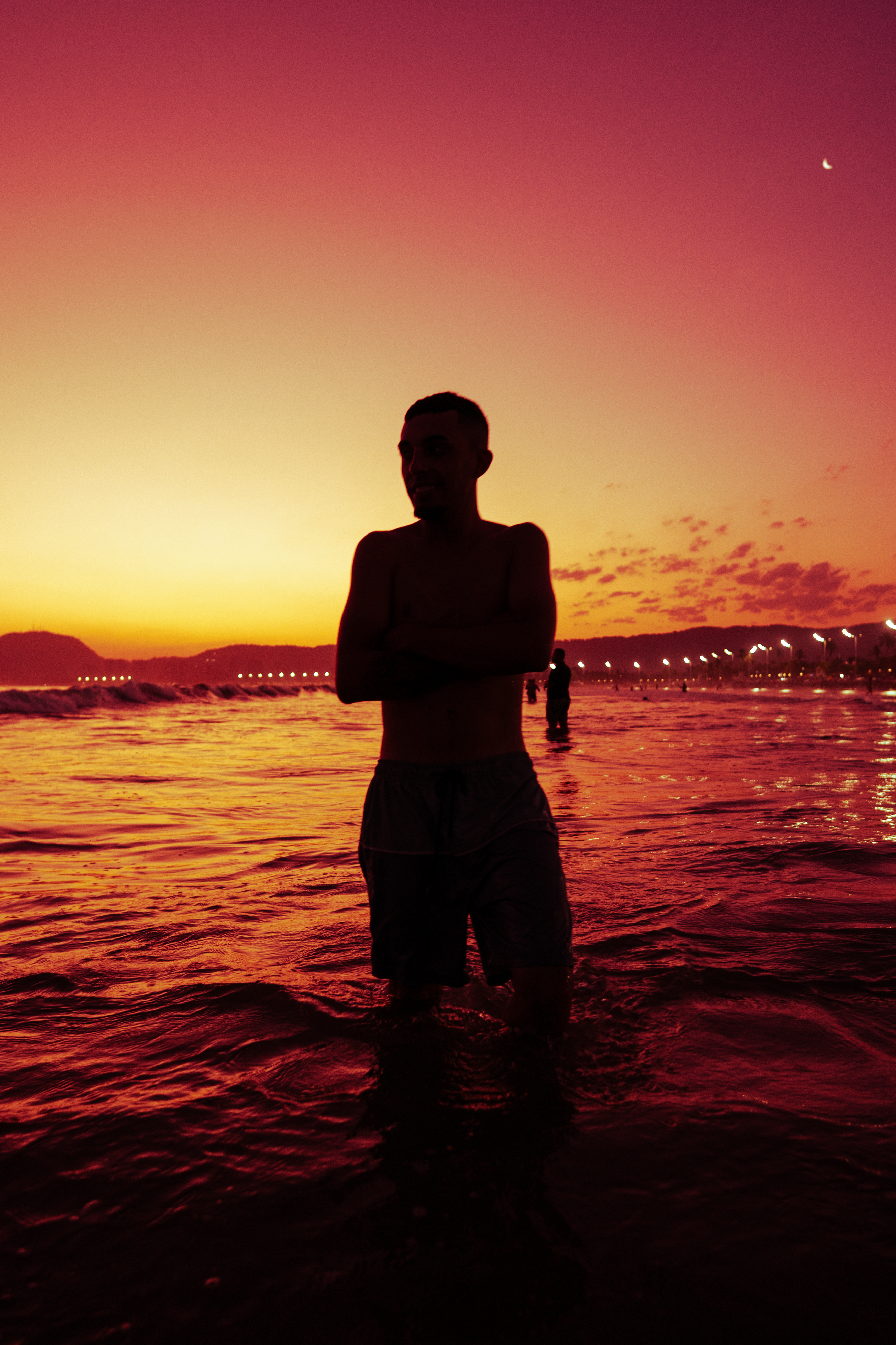 Silhouette of Man Standing in Water on Seashore at Sunset · Free Stock ...