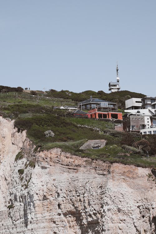 A house on a cliff with a steep hill behind it