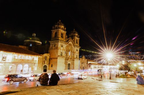 Free Vibrant night scene of Cusco's city streets, featuring illuminated colonial architecture and bustling urban life. Stock Photo