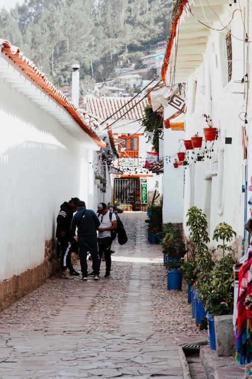 Free Explore a picturesque alleyway in Cusco, Peru featuring locals, vibrant decorations, and traditional architecture. Stock Photo