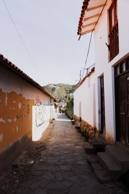Free A scenic alleyway in Cusco, Peru featuring traditional architecture and vibrant colors. Stock Photo