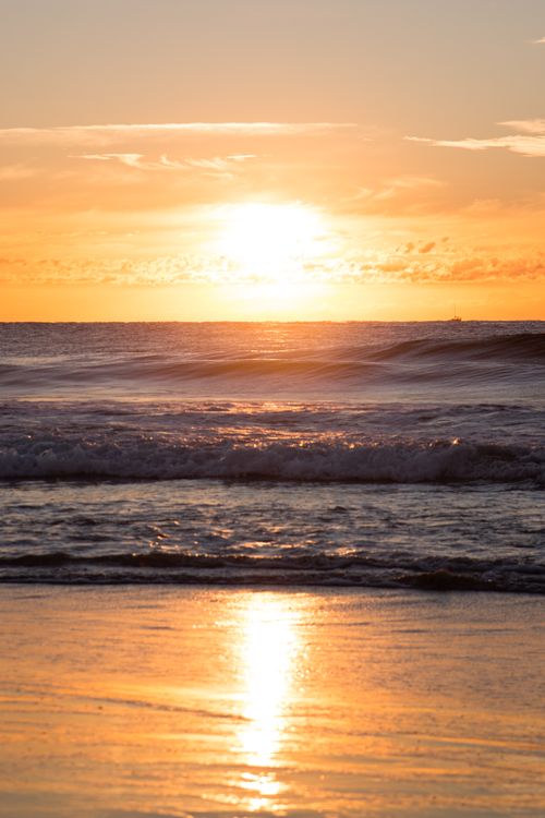 Free Beautiful sunrise over the ocean with golden reflections on the water at Gold Coast, Australia. Stock Photo