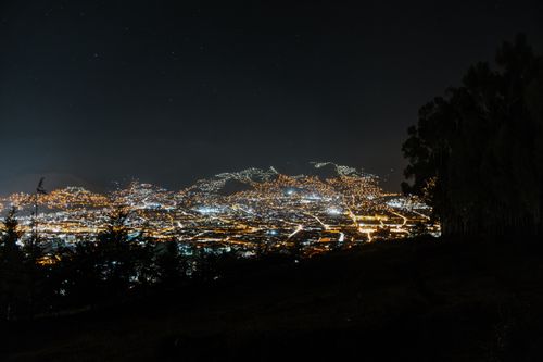 Free Stunning night view of Cusco city lights under a starry sky, captured from a hillside. Stock Photo