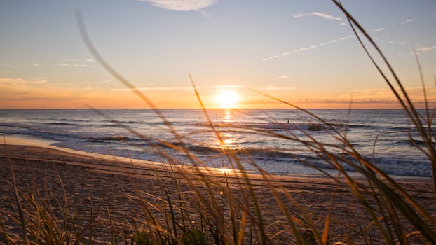 在澳大利亚黄金海岸宁静的海滩上，金色的日落伴着轻柔的海浪，氛围宁静