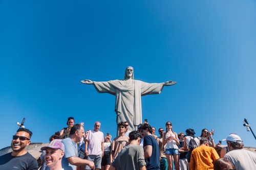 Free Tourists gather at the iconic Christ the Redeemer statue under clear blue skies in Rio de Janeiro, Brazil. Stock Photo