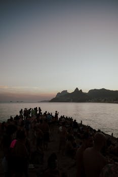 People enjoying the picturesque sunset at Ipanema Beach in Rio de Janeiro, Brazil.