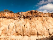 在明亮的蓝天下，令人惊叹的岩石悬崖展示了独特的侵蚀模式