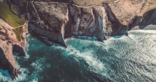 Bird's-eye Photography of Rocky Cliffs Near Body of Water