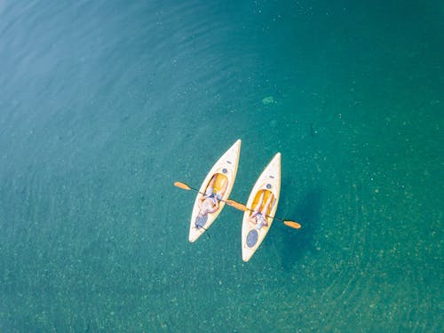 Bird's Eye View of Two People Canoeing on Body of Water