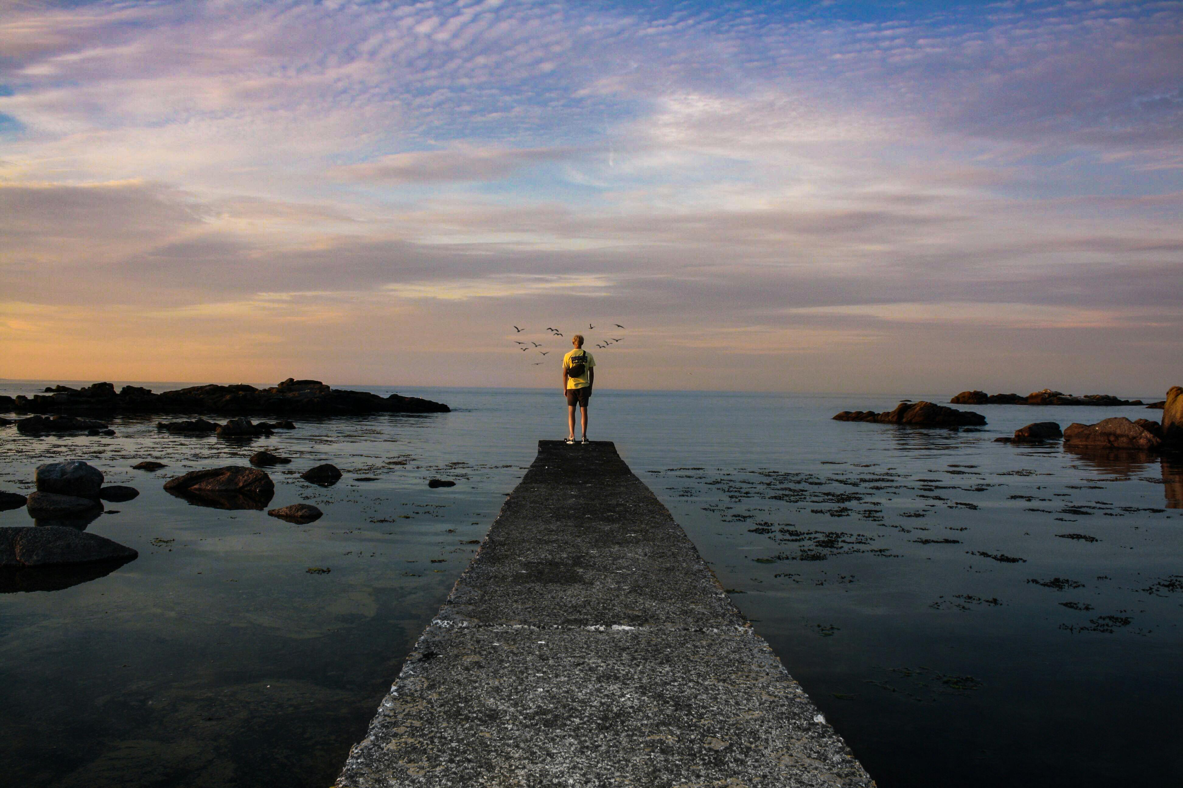 这张在丹麦码头拍摄的照片，捕捉了海边宁静的日落场景，非常适合为旅行和生活方式提供灵感