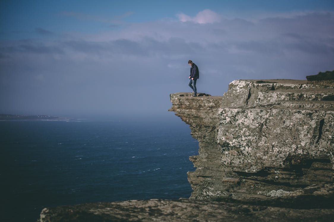 Free Man Standing on Cliff Stock Photo