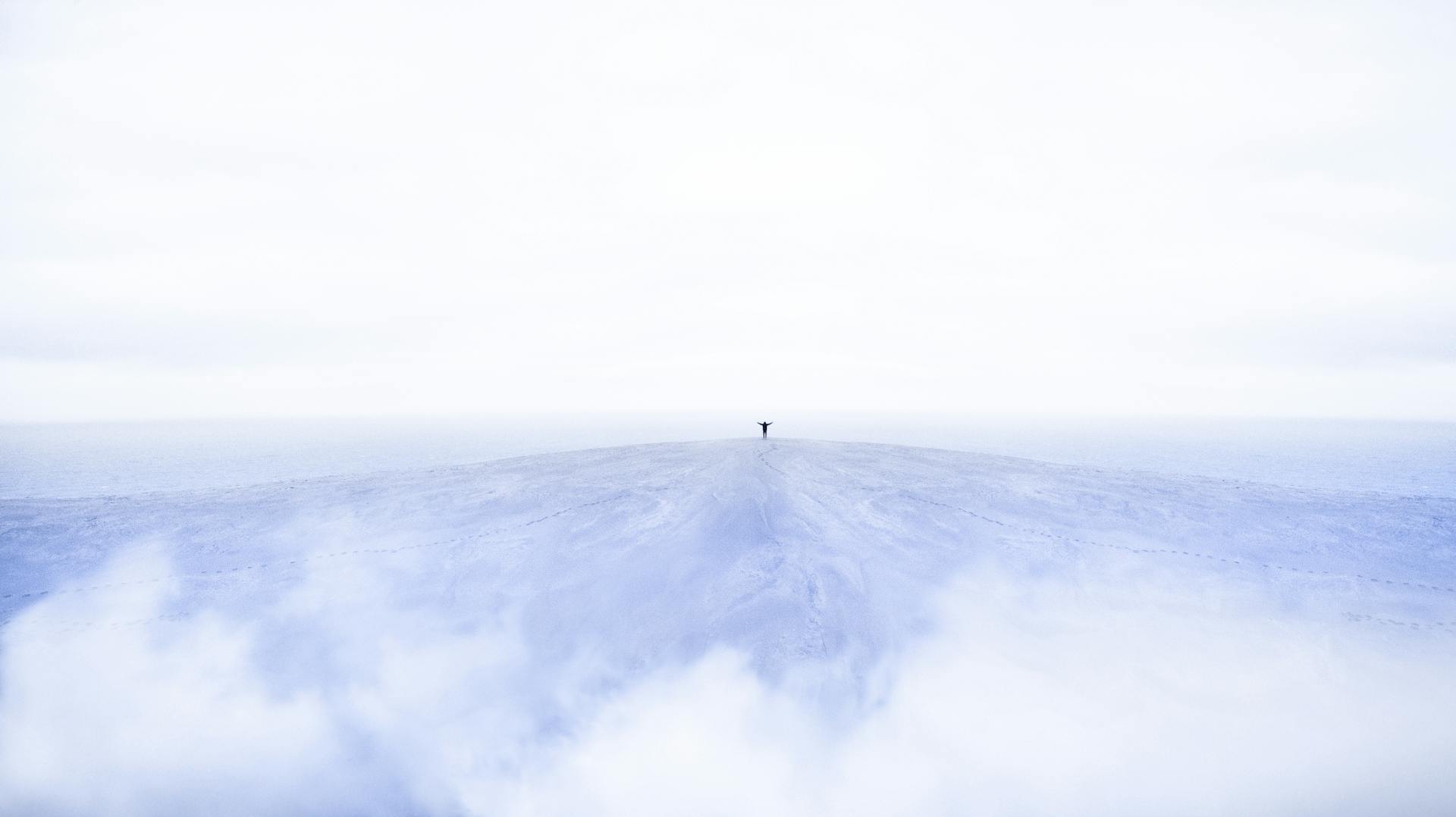 Person Standing On Top Of Mountain