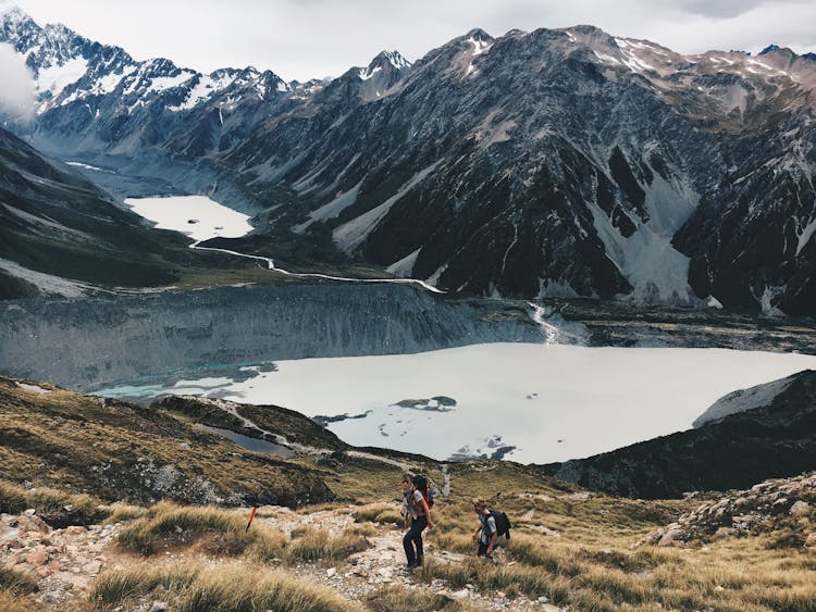 Two Hikers Climbing Up Mountain