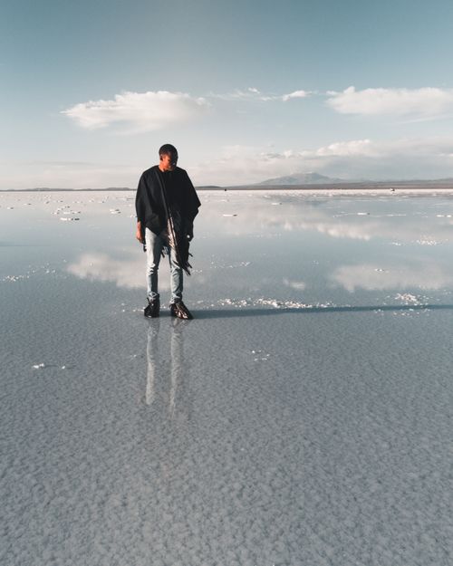 Free A man stands on the reflective surface of Uyuni Salt Flats, capturing a serene and tranquil scene. Stock Photo