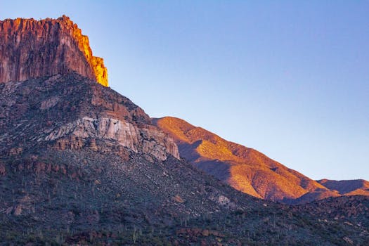 Stunning view of a rocky mountain illuminated by sunset in an arid desert region.