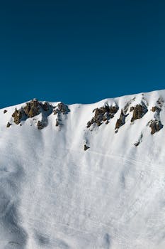 白天，白雪皑皑的山峰尽显壮丽景色，凸显了大自然的美丽