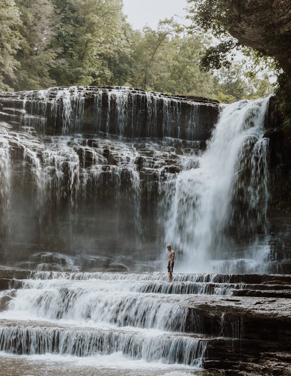 Person Standing Near Waterfalls