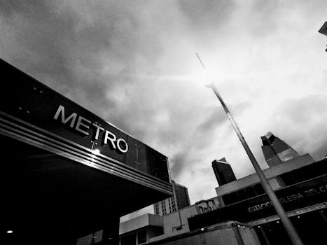 Dramatic monochrome image capturing a metro station under a cloudy sky.