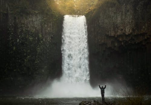Free Photo of Person Standing Near Waterfalls Stock Photo