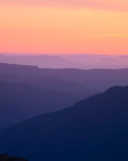 Free Beautiful layers of mountains under a vibrant sunrise sky in Washington State. Stock Photo