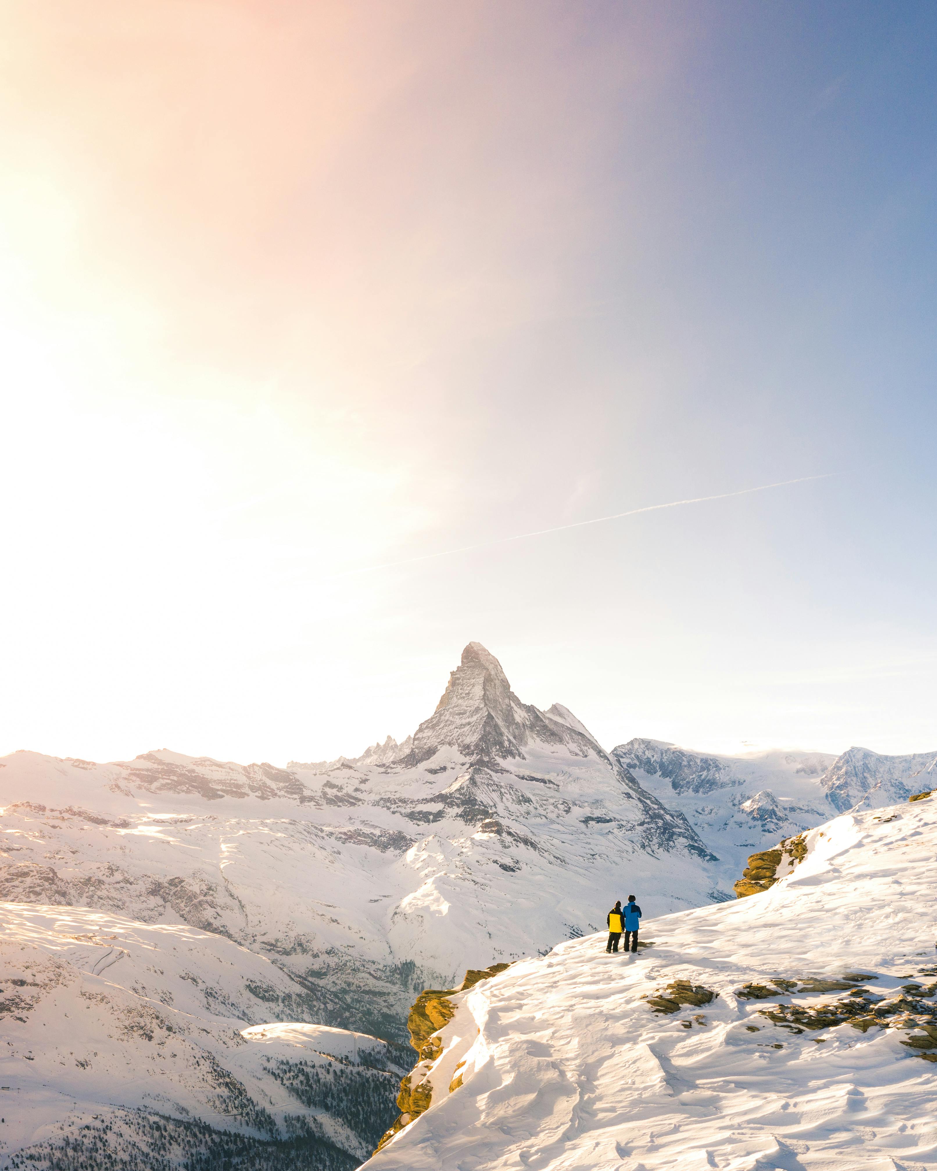 Couple Standing by Cliff Covered With Snow