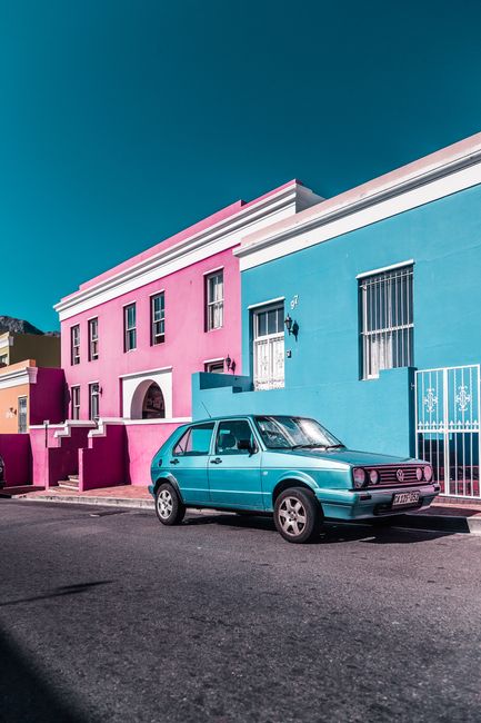 Classic car parked in Bo-Kaap, Cape Town, showcasing vibrant architecture and culture.