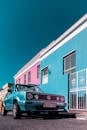 在南非开普敦，一辆经典古董车停在色彩缤纷的房屋旁，展现出充满活力的建筑风貌
