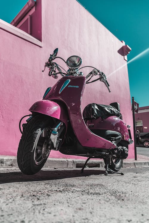 Scooter Rosa Estacionada Ao Lado Da Parede De Concreto Rosa