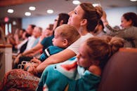 一位母亲和她的孩子们在室内聚精会神地听着，温暖的家庭纽带清晰可见