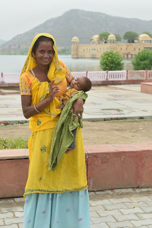 Woman Standing and Carrying Baby