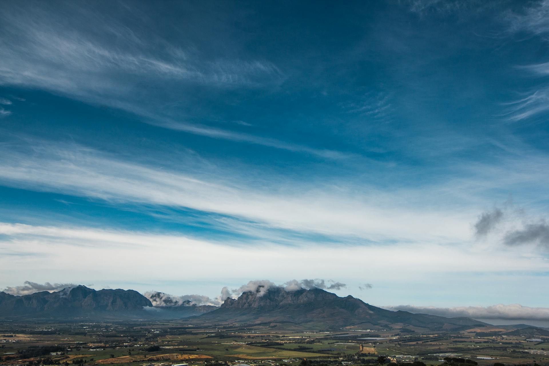 Stunning panoramic landscape of Cape Town mountains with a vast blue sky and scenic view.