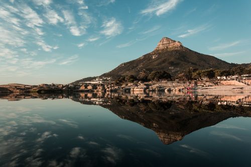 Free Stunning reflection of Lion's Head mountain in tranquil Cape Town waters at dawn. Stock Photo