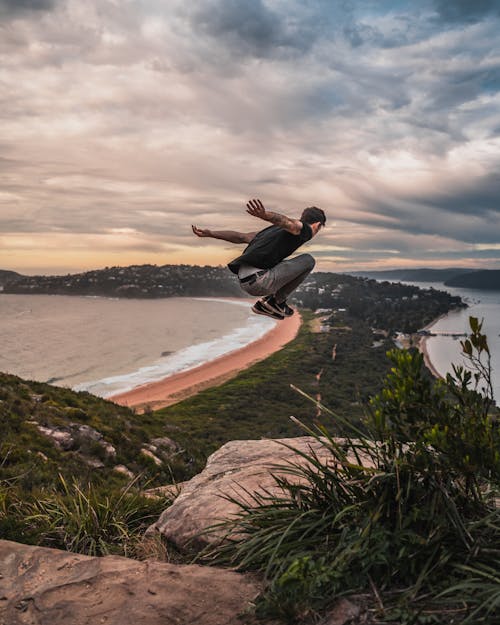 Free Time Lapse Photography of Man Jumping From Mountain Cliff Stock Photo
