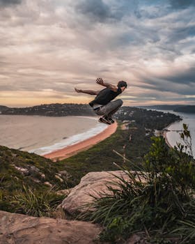 A person jumping with excitement on a cliff, capturing the scenic view of Palm Beach, Australia.