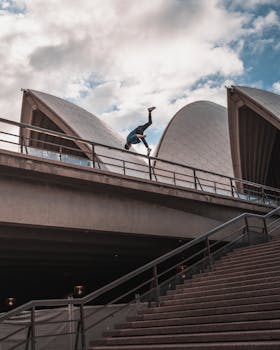 Man performing a parkour trick on the Sydney Opera House roof, capturing urban adventure