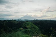 在多云的天空下，郁郁葱葱的山丘环绕着马永火山，构成了一幅壮丽的鸟瞰图