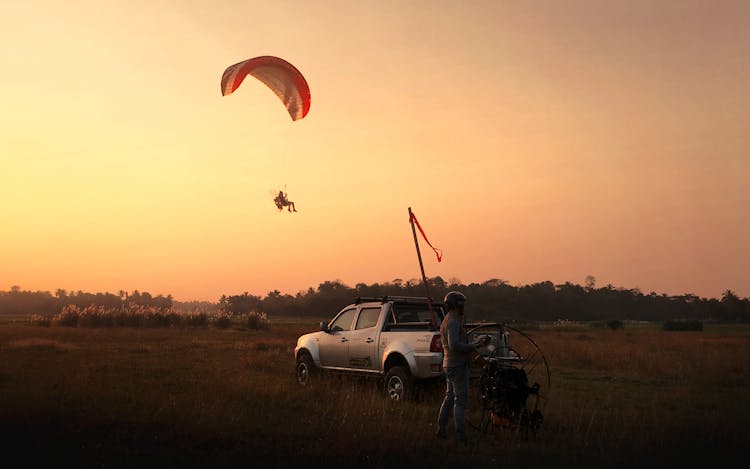 Man Riding Parachute During Golden Hour