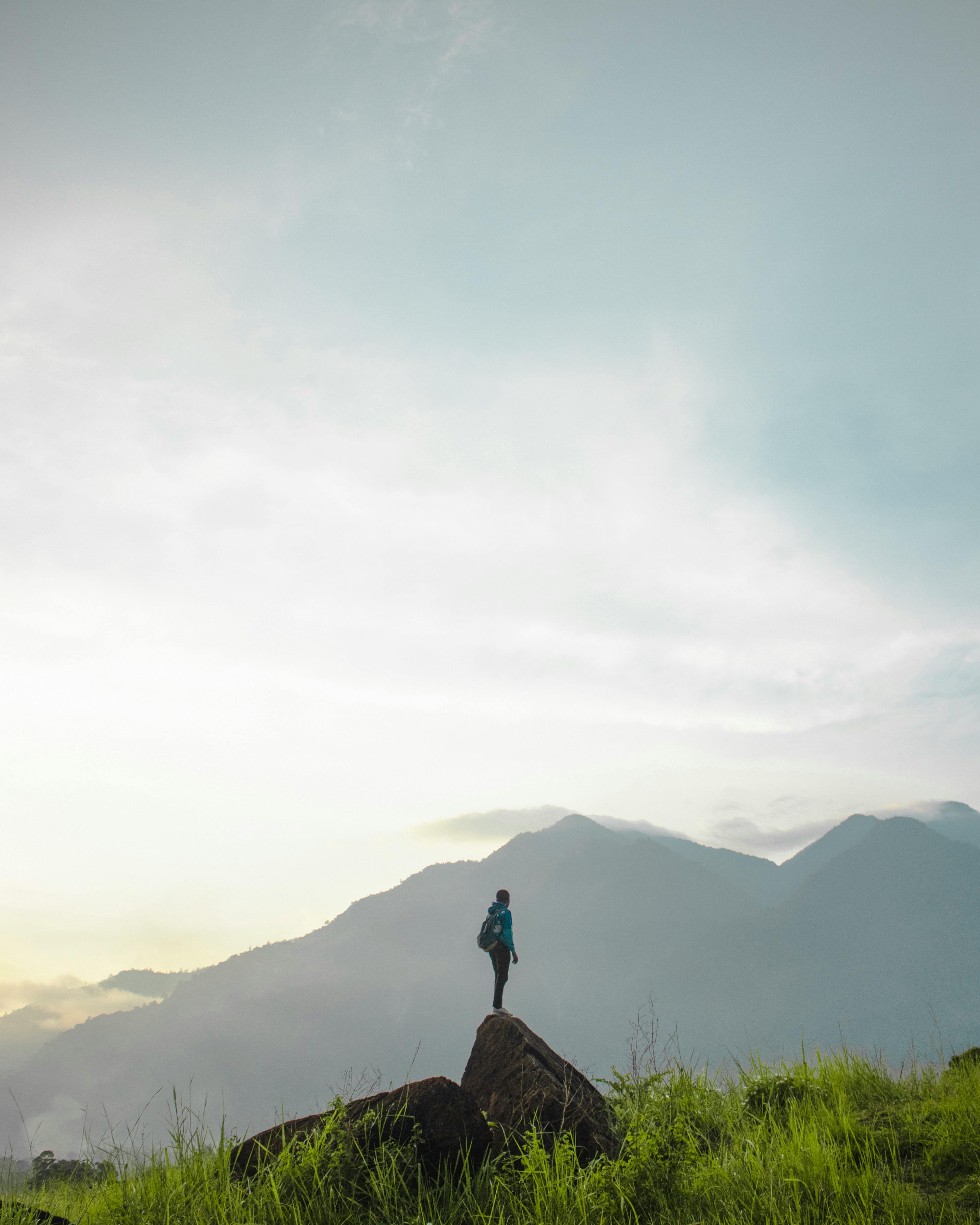 在印度尼西亚巴布亚的雾山中，一名徒步旅行者独自站在一座小山上