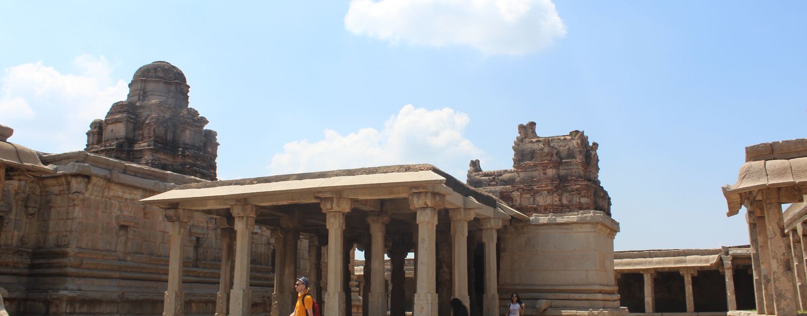 Explore the historic architecture of ancient stone temple ruins in India under a vibrant blue sky.
