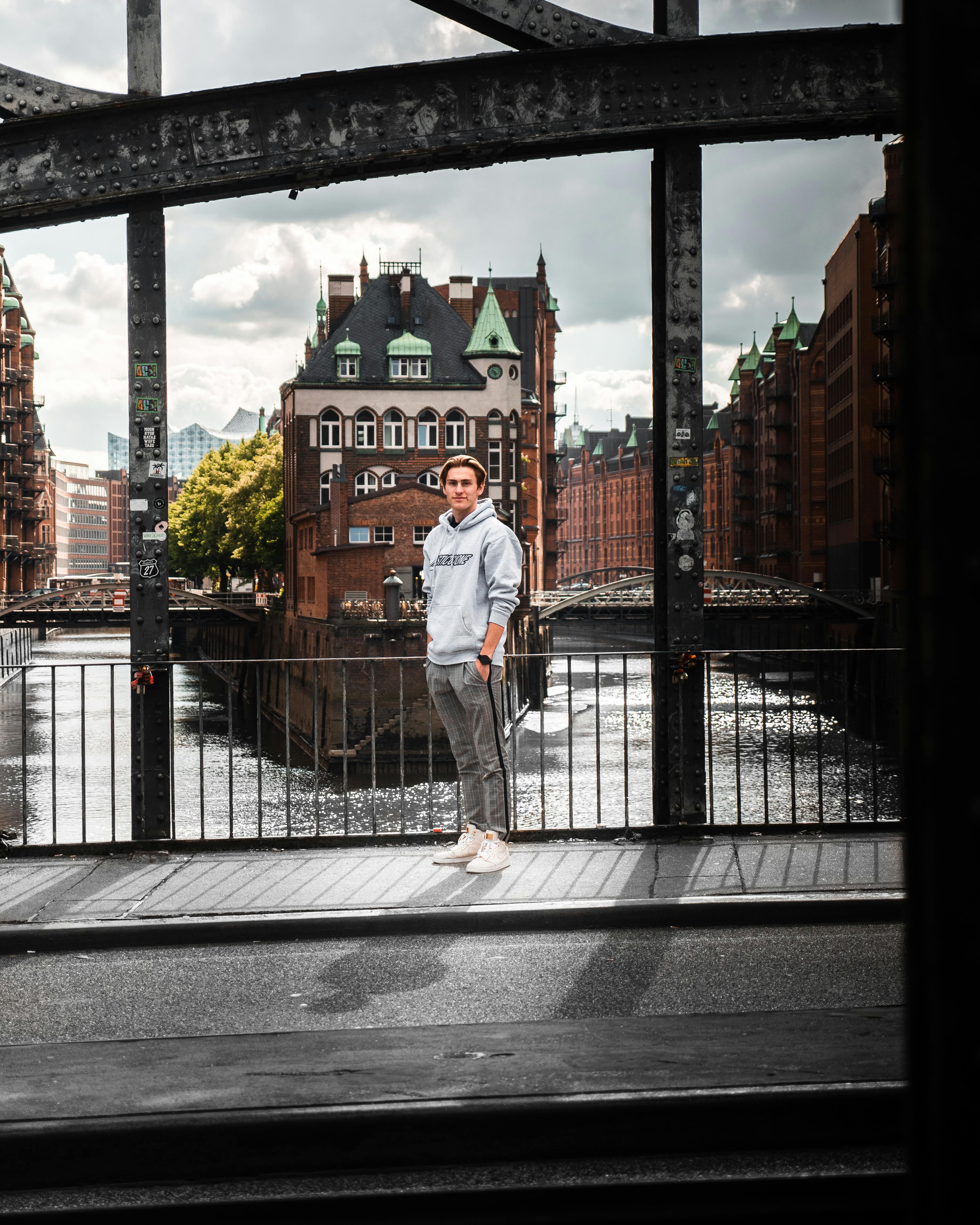 在汉堡的一座桥上，一名年轻人站着，背景是标志性建筑