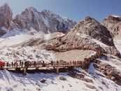 游客徒步走过中国漓江白雪皑皑山峰上的木桥