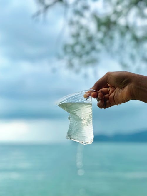 Photo of Person Holding Plastic Cup With Water