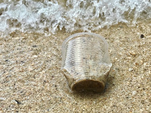 Foto De Close Up De Copo De Plástico Na Areia