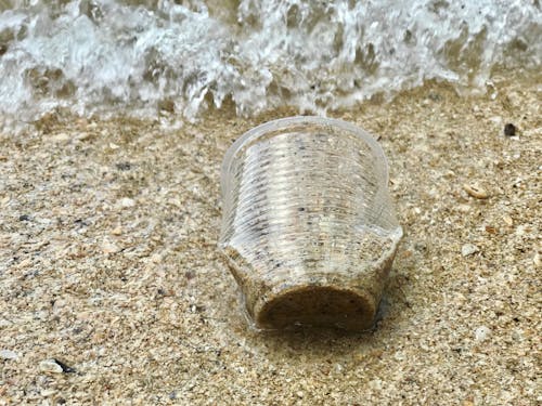 Foto En Primer Plano Del Vaso De Plástico Sobre Arena.