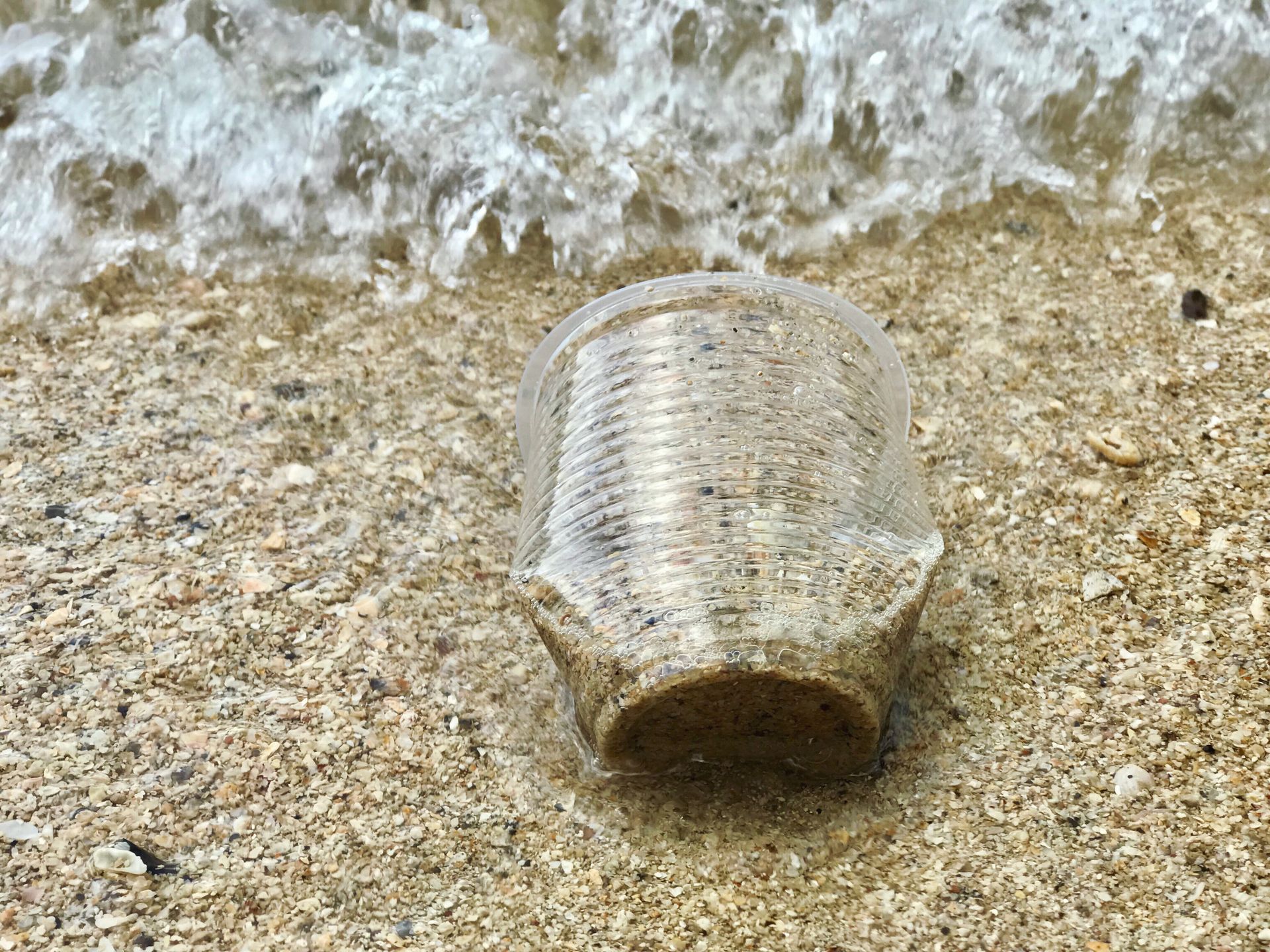 Close-Up Photo of Plastic Cup On Sand