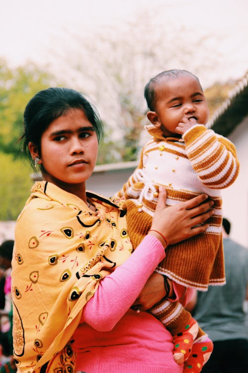 Free Photo of Woman Carrying Her Baby Stock Photo