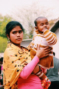 一位母亲在户外深情地抱着孩子，尽显母爱